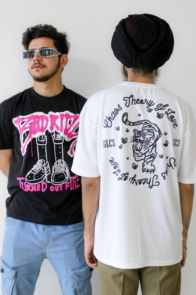 Two young men in graphic T-shirts and sunglasses showcase modern streetwear style.