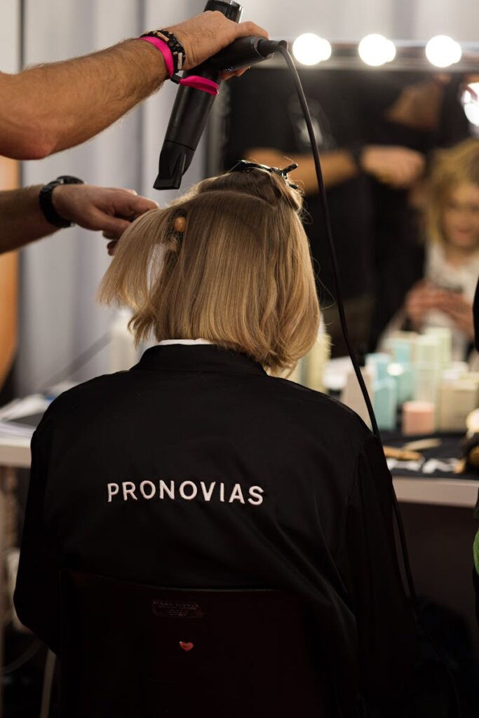 A stylist works on a model's hair backstage at a fashion show in Barcelona, Spain.