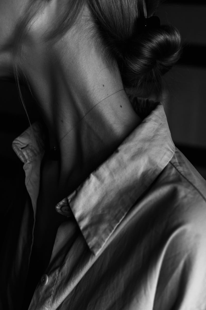 Elegant black and white portrait highlighting the neckline and blouse.