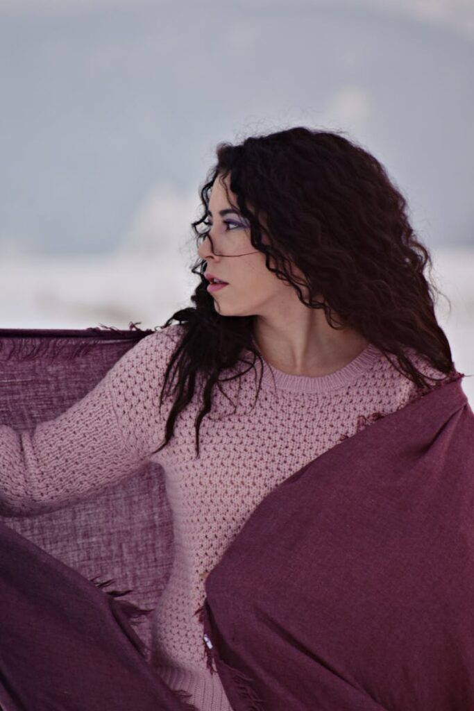 Elegant woman with a scarf in a winter setting, showcasing seasonal fashion.