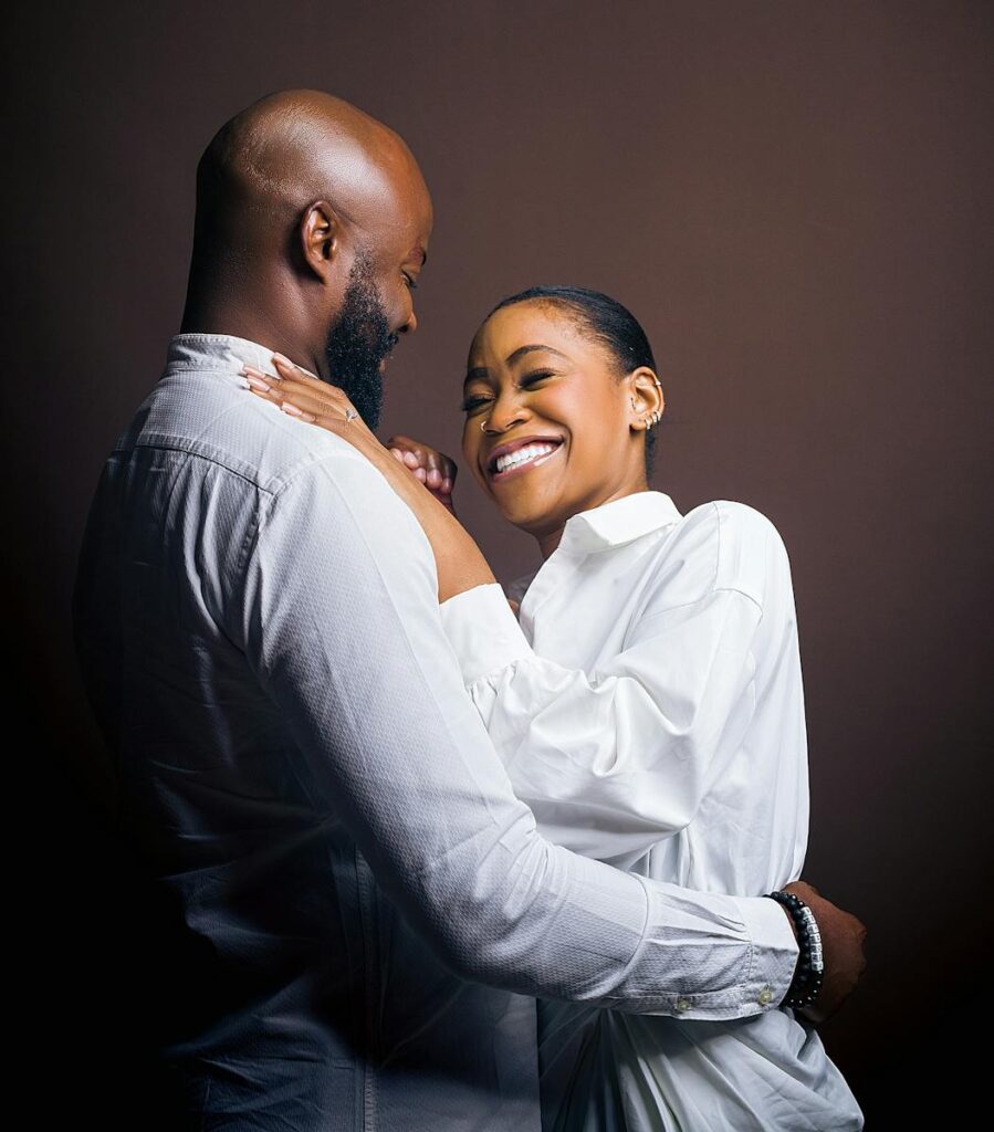 Charming portrait of a couple joyfully embracing against a neutral background.