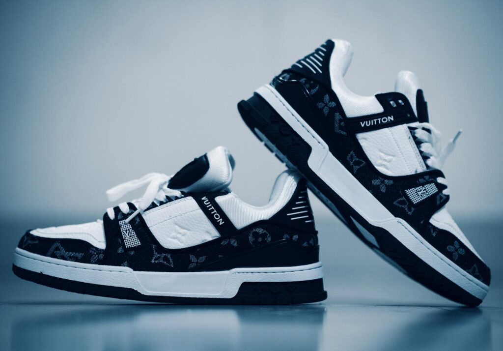 Close-up of black and white designer sneakers with distinctive patterns in a studio setting.