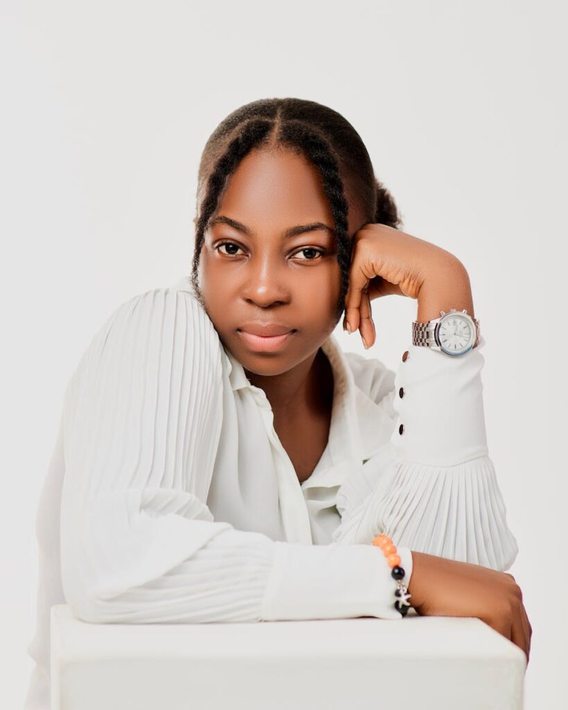 Elegant studio portrait of a woman in a white blouse with a watch, posing thoughtfully.