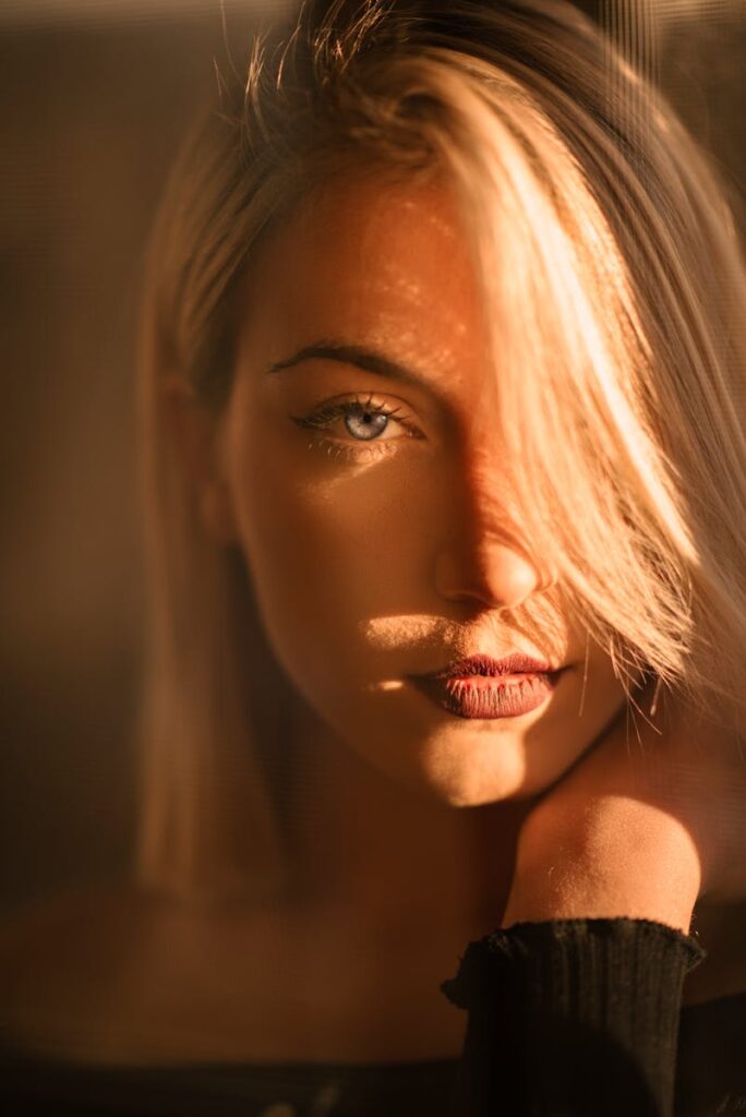 Captivating portrait of a blonde woman bathed in warm golden hour light.