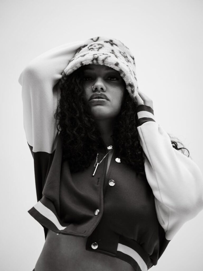 Stylish black and white portrait of a woman in fashionable attire with a confident pose.