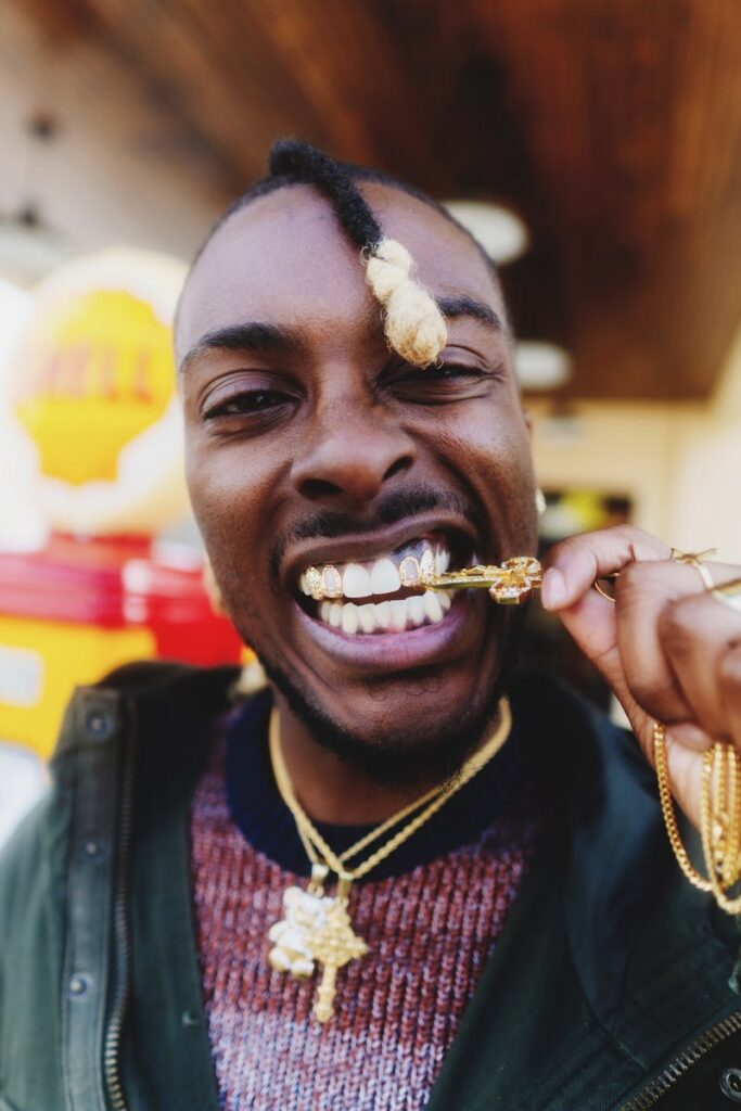 Dynamic close-up portrait of a man in Atlanta showcasing gold jewelry and bold expression.