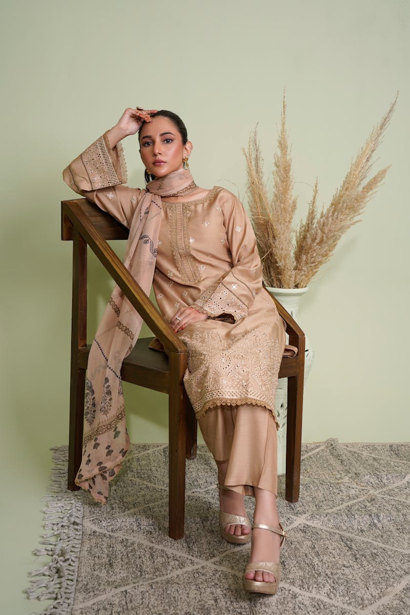 Stylish Pakistani woman in traditional dress posing in a studio setting.
