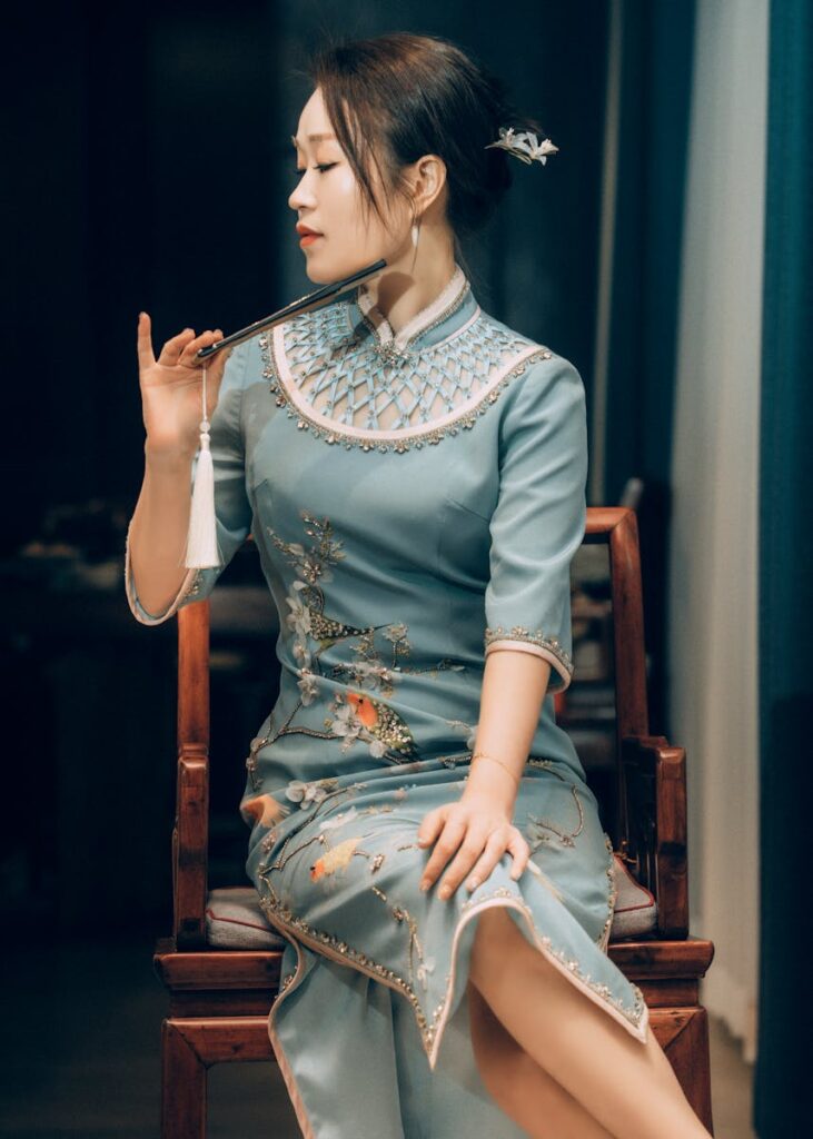 Portrait of a young woman in traditional Chinese dress seated elegantly with serene expression.