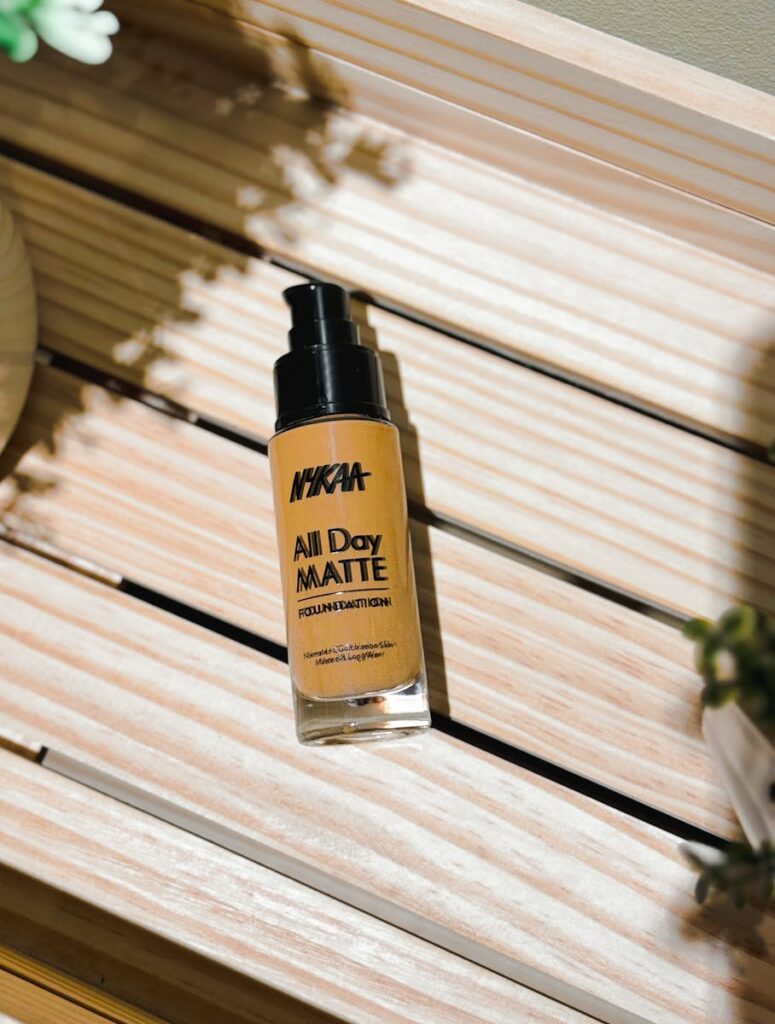 Close-up of a matte liquid foundation bottle on a wooden surface with natural lighting.