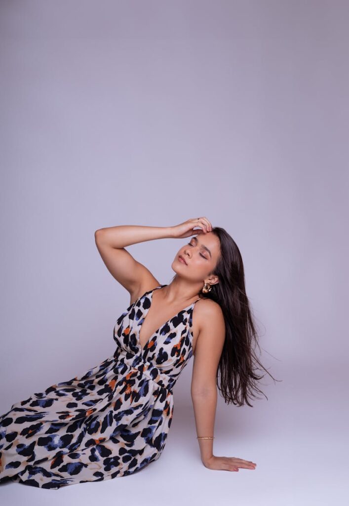 Model in leopard print dress posing against a purple background.