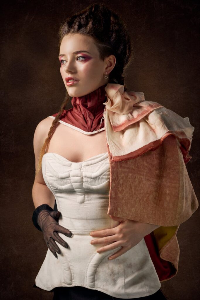 A beautiful woman posing in a vintage corset with artistic makeup and hairstyle.