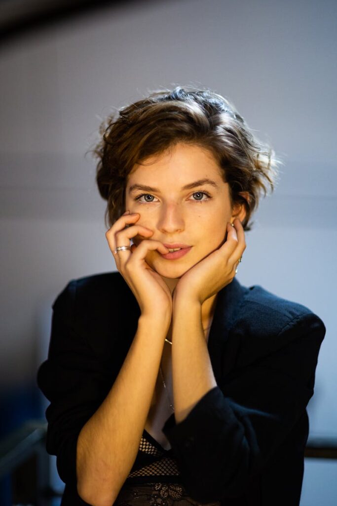 Elegant woman with short hair posing indoors, showcasing fashion style.