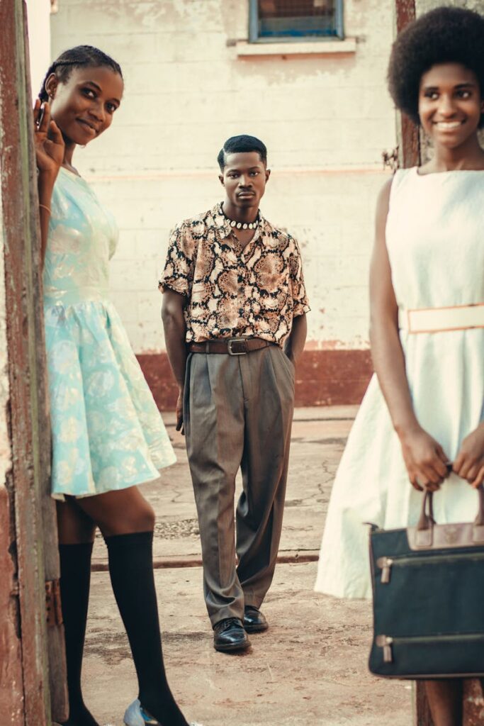 Group of friends in retro fashion posing outdoors, showcasing stylish dresses and shirts.