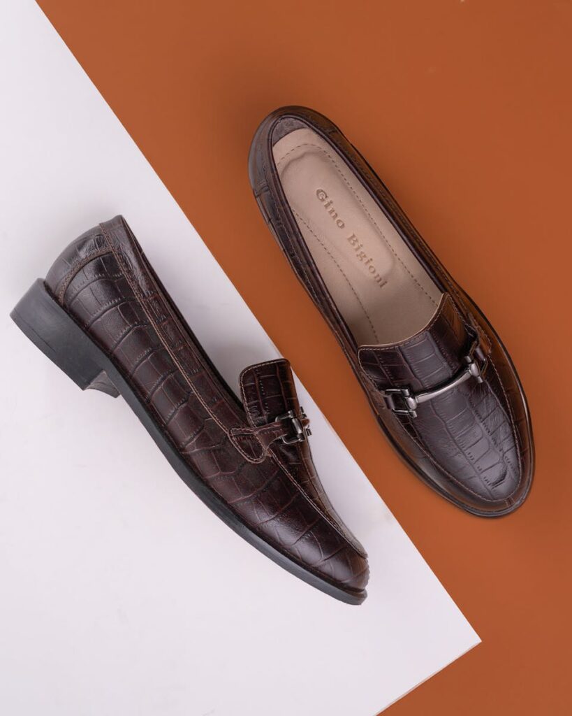 Stylish brown leather dress shoes with upscale design on contrasting background.