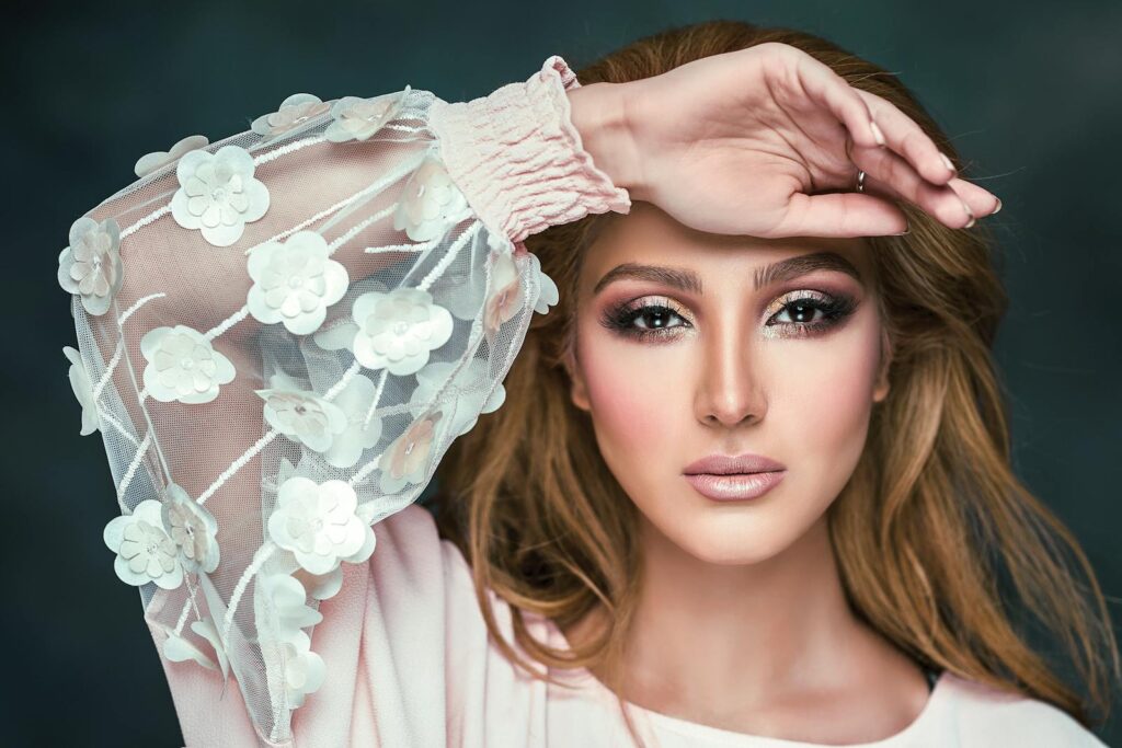 Stunning portrait of a woman in a studio setting, highlighting floral fashion and makeup.