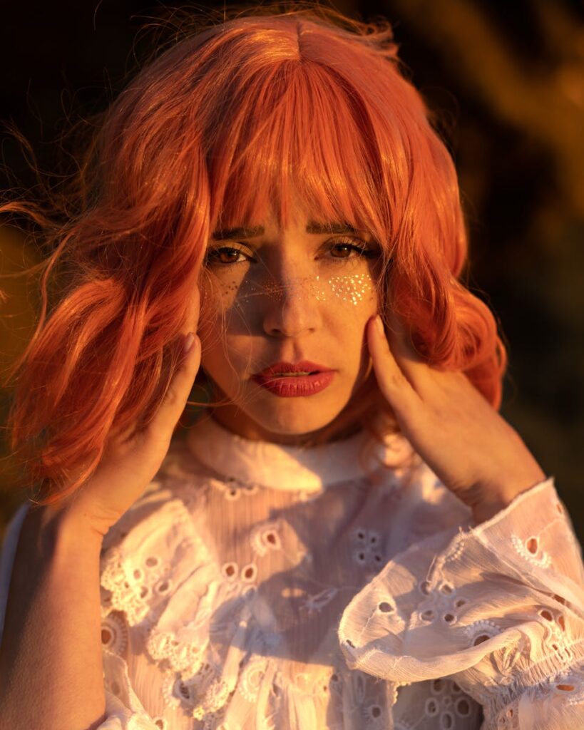 Warm portrait capturing a redheaded woman in San Francisco with glittery makeup.