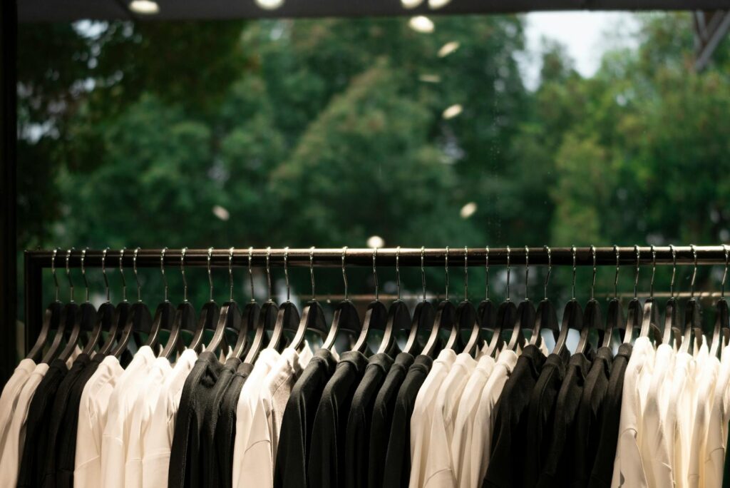 A modern clothing display featuring black and white shirts on hangers inside a fashion store.