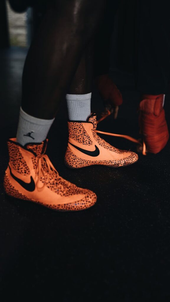 Dynamic close-up of orange boxing shoes in a training environment.