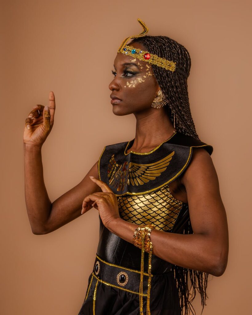 Portrait of a woman in Egyptian-style costume with elegant pose on a neutral background.