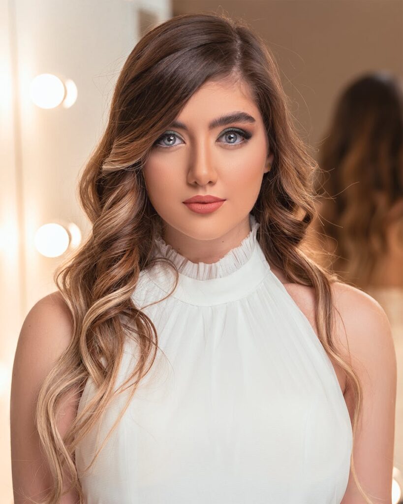 Stunning portrait of a woman with wavy brown hair and elegant makeup, styled for a sophisticated look.