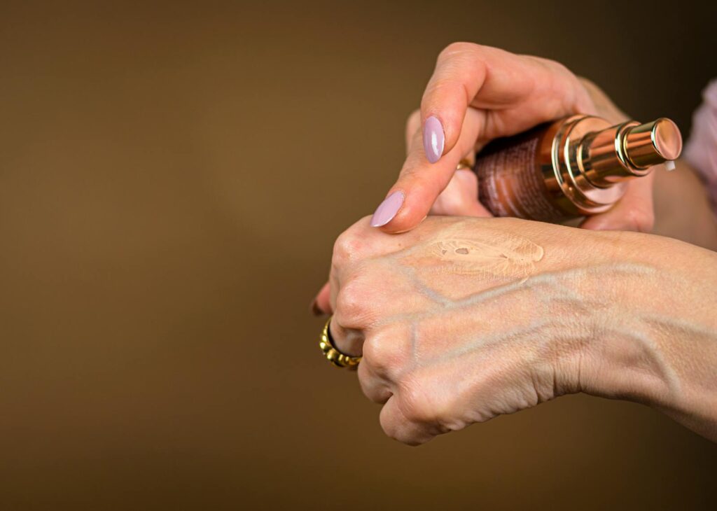 A detailed shot showing foundation being applied to hand skin care routine.