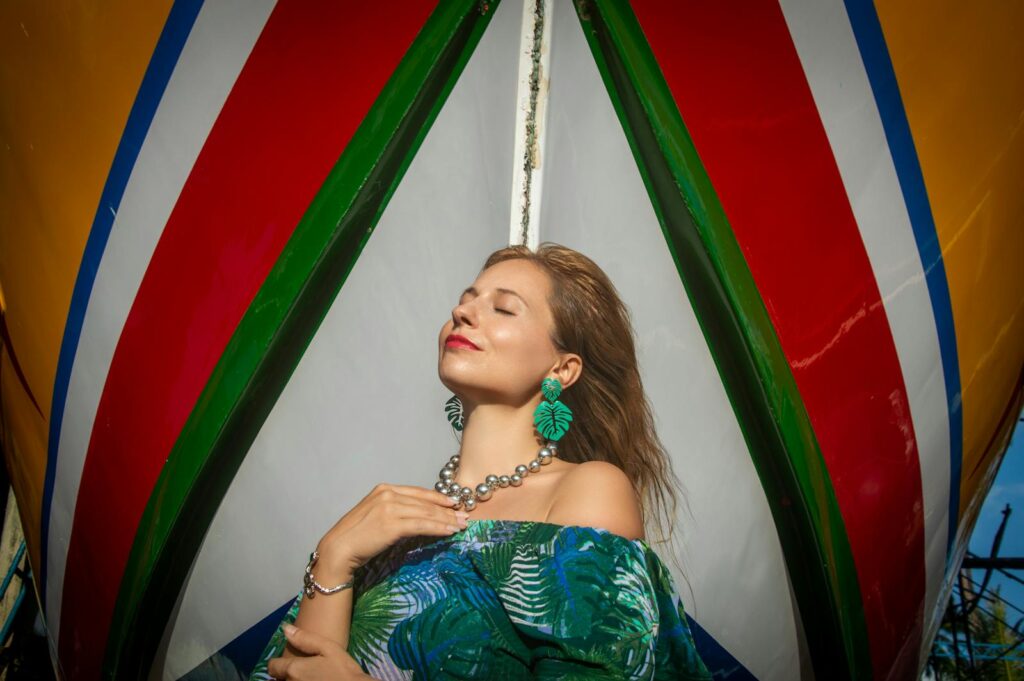 Woman relaxing by a vibrantly painted boat, enjoying the sunshine.