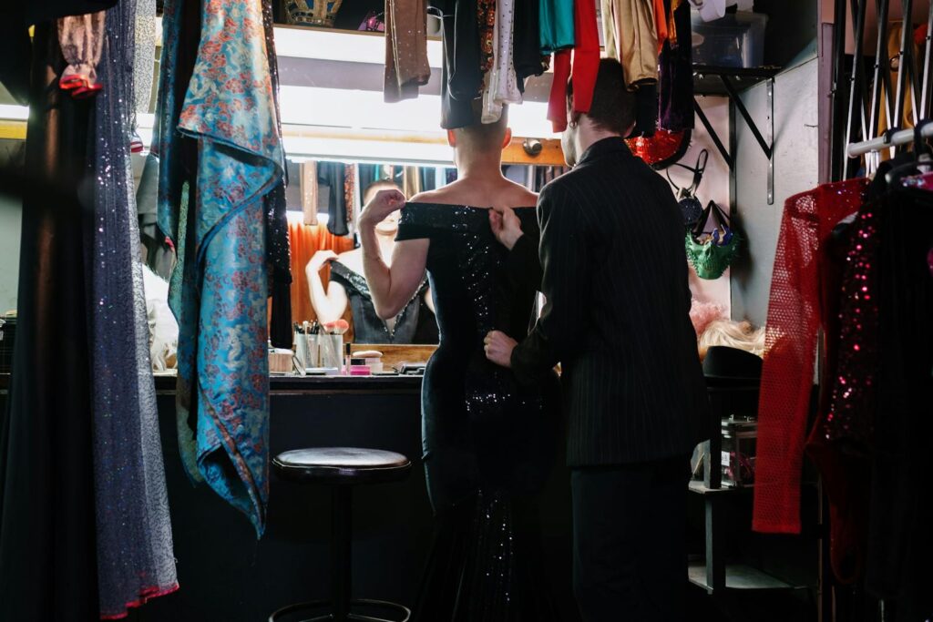 A captivating backstage moment showing the transformation process with dresses and makeup.