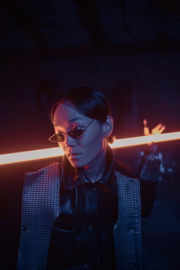 A stylish model poses in a futuristic cyberpunk setting with neon lighting.