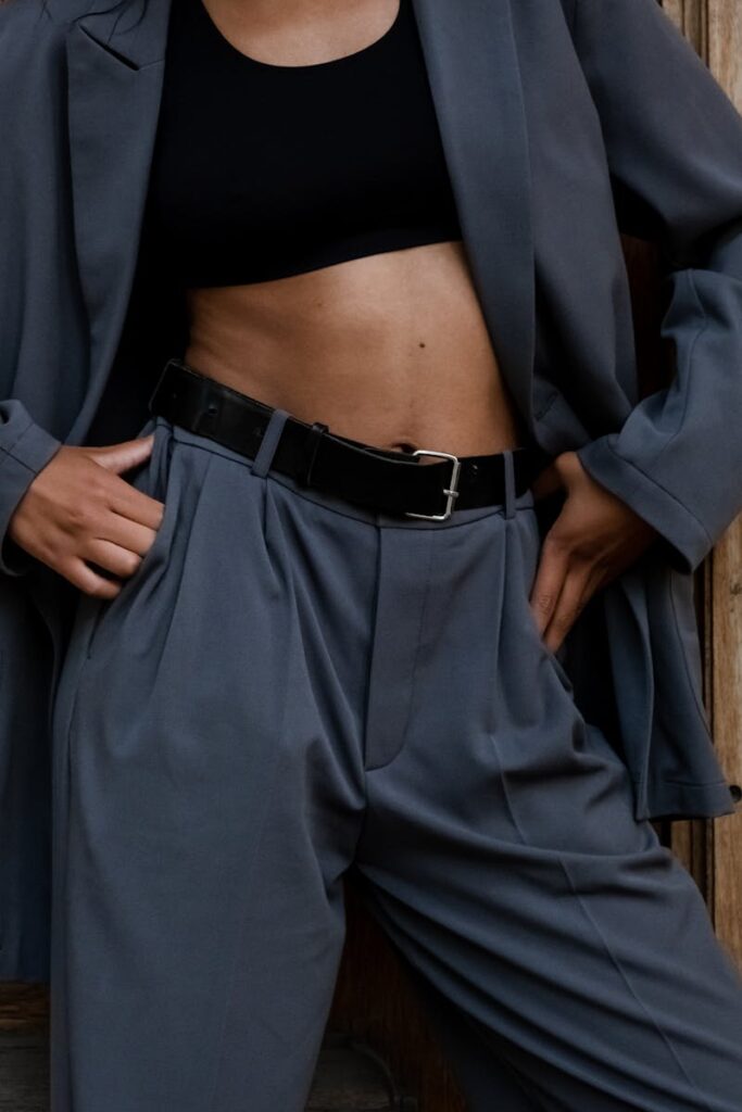 Fashionable model showcasing a trendy gray suit with a black crop top, focusing on style and elegance.