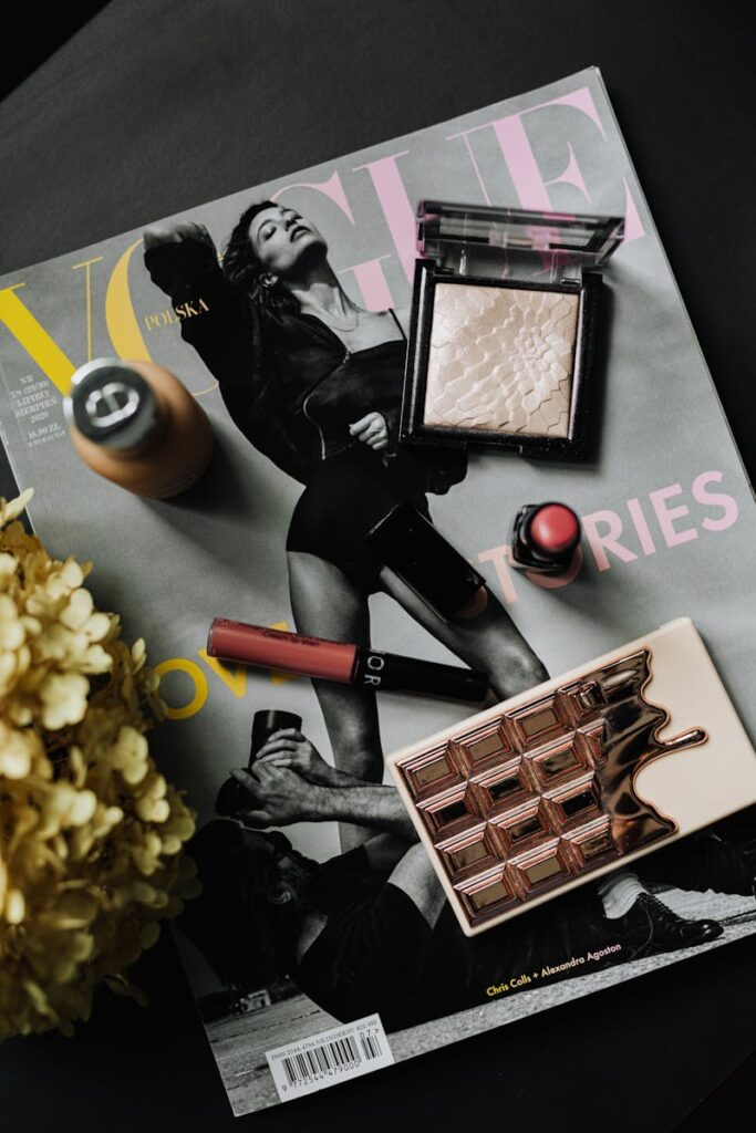 Stylish flat lay of makeup essentials on a Vogue magazine cover.