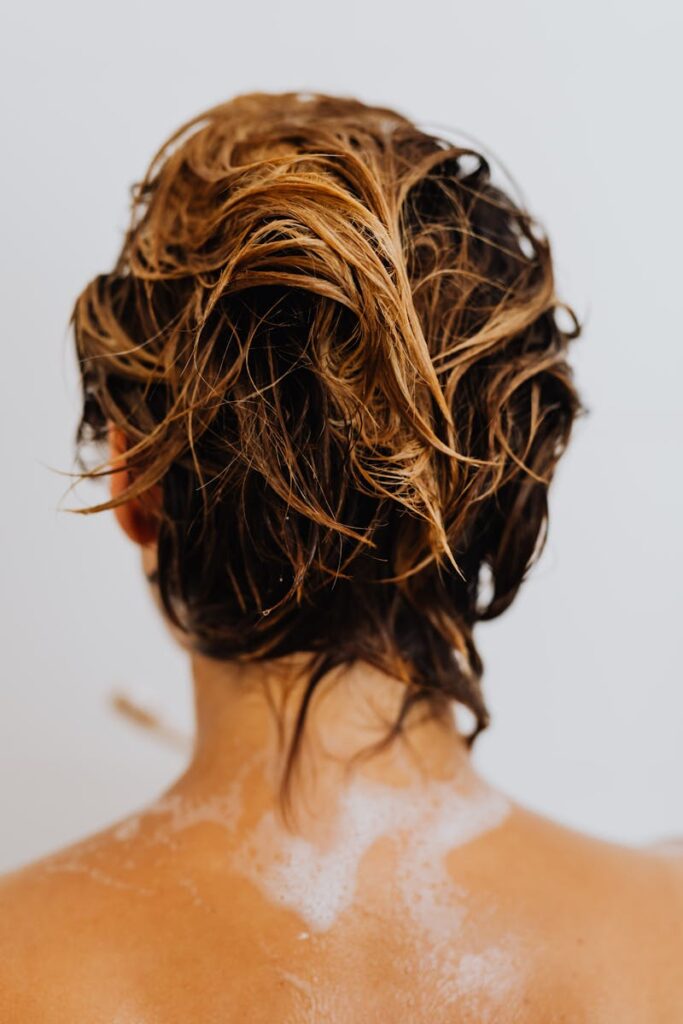 Close-up of wet blonde hair viewed from behind, capturing a moment of showering and wellness.