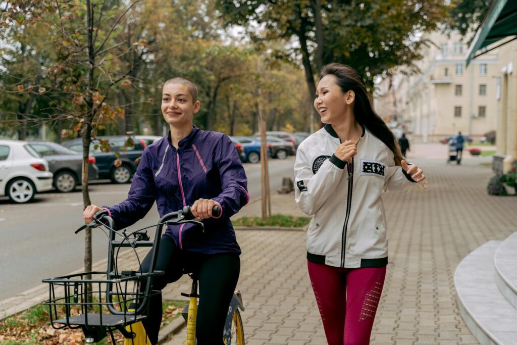 Two women jogging and bicycling outdoors, capturing a healthy and active lifestyle.