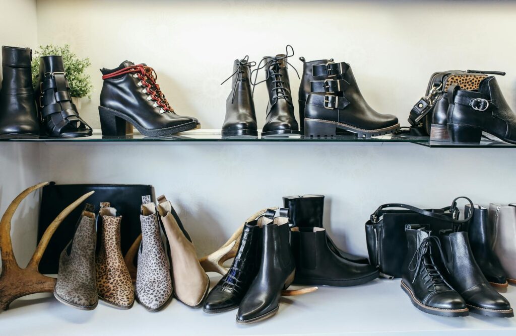 Diverse assortment of leather and animal print boots elegantly displayed on shelves for fashion enthusiasts.