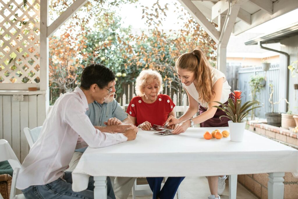 Family sharing photos while seated outdoors, surrounded by nature and smiles.