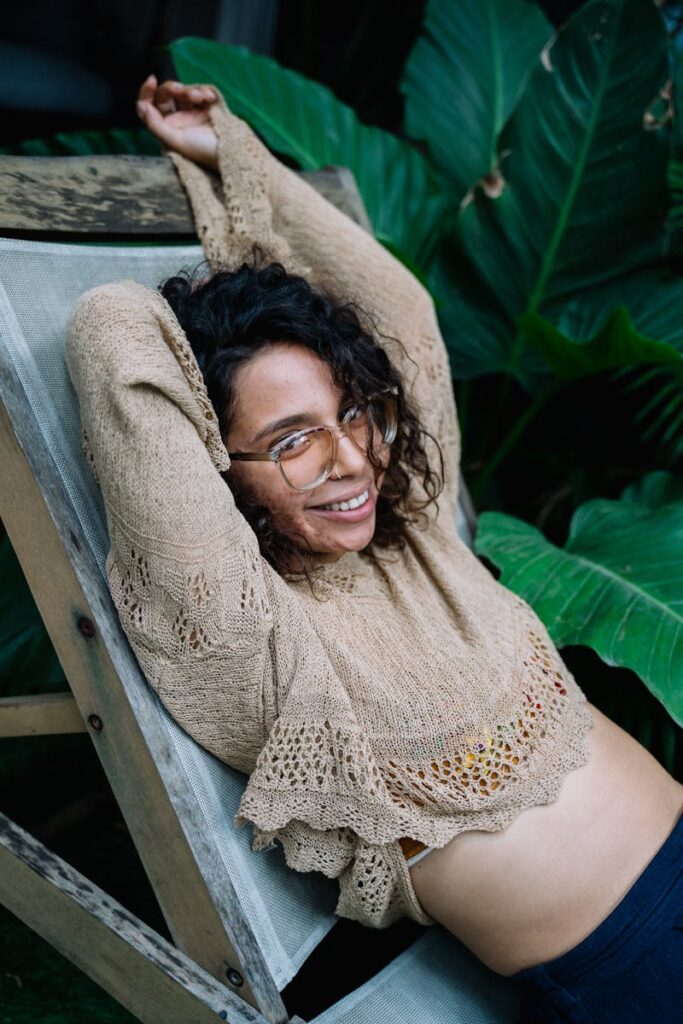 Charming young woman relaxes outdoors on a sunny day, exuding happiness and warmth.