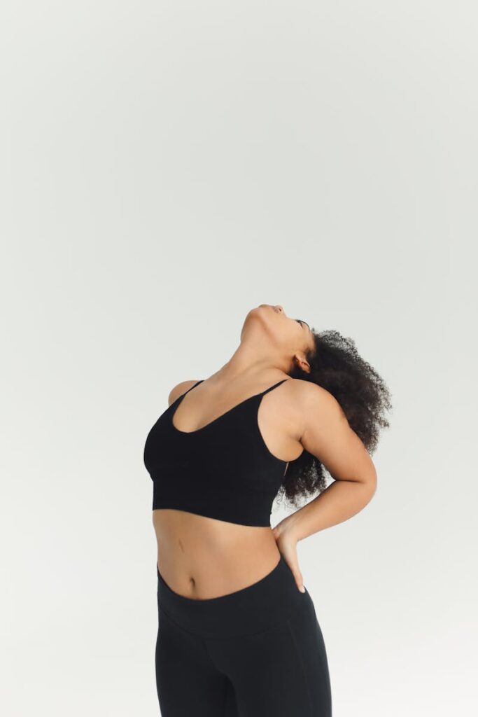 Woman stretching in black sportswear, emphasizing fitness and flexibility.