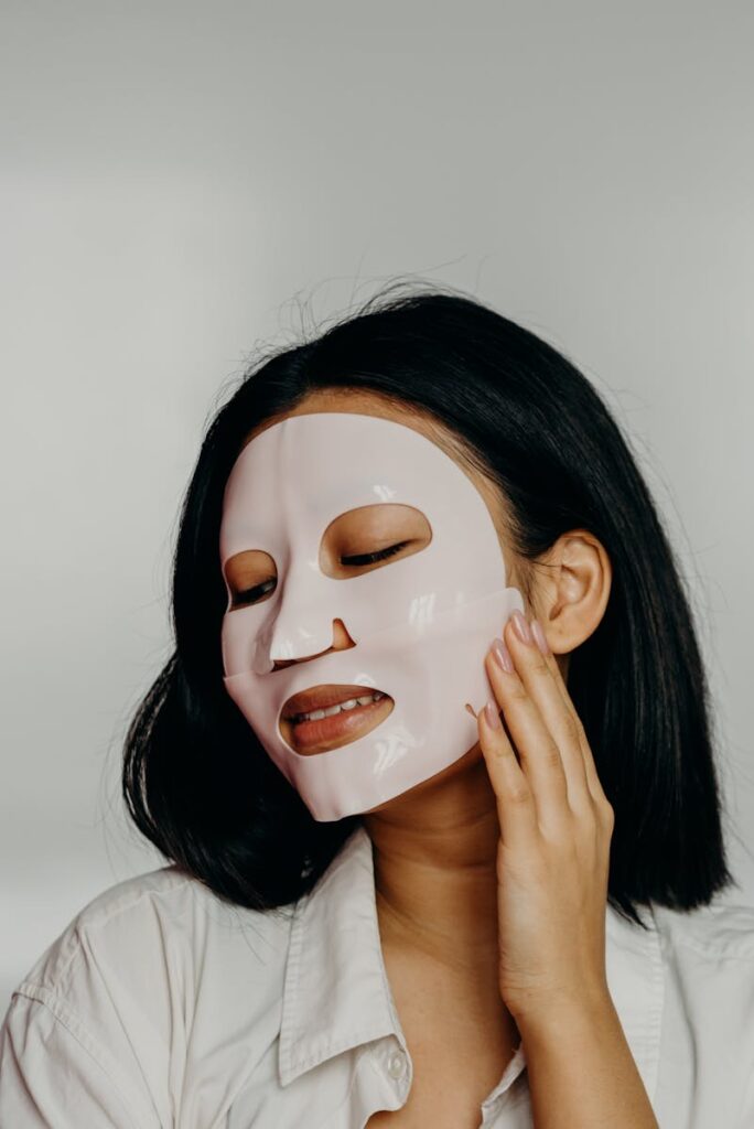 Asian woman enjoying a relaxing skincare routine with a face mask, promoting self-care and wellness.