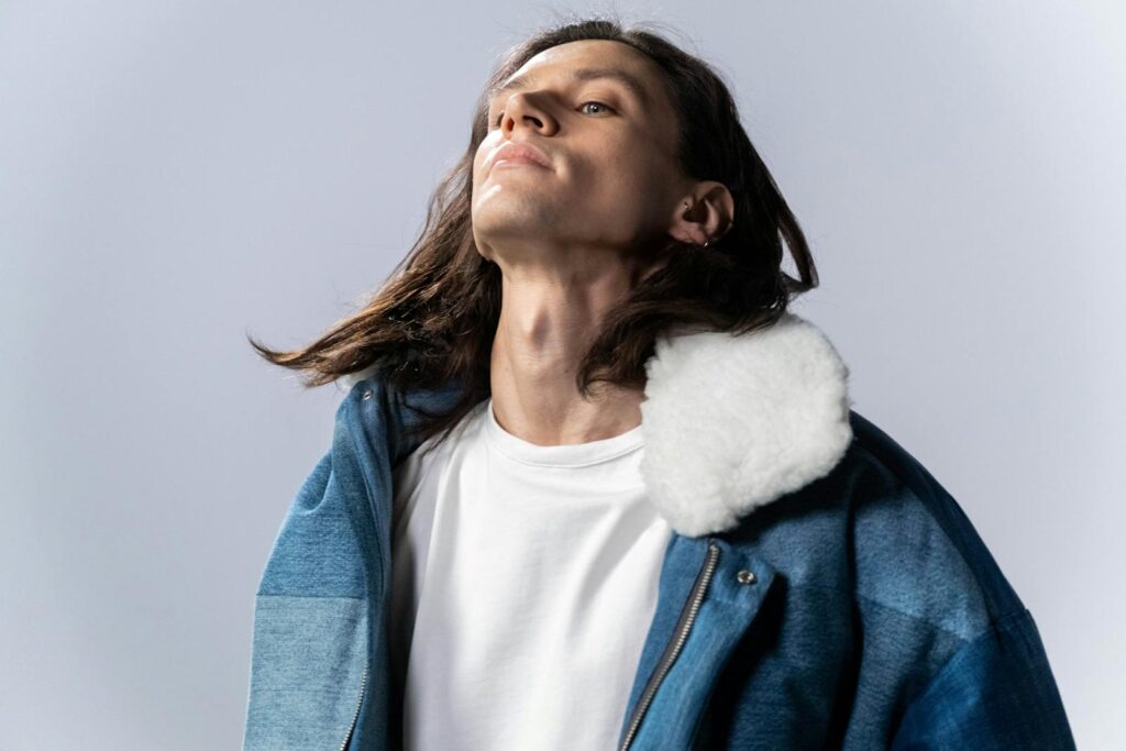 Stylish studio portrait of a man in a denim jacket with a fur collar. Perfect for fashion shoots.