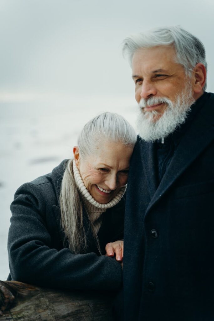 Senior couple enjoying a loving moment outdoors in winter, displaying affection and warmth.