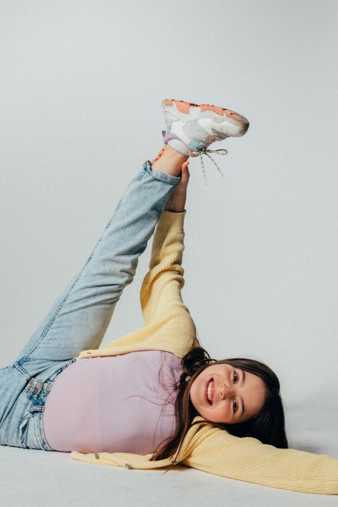 Cheerful girl in playful pose wearing casual outfit indoors with a bright smile.