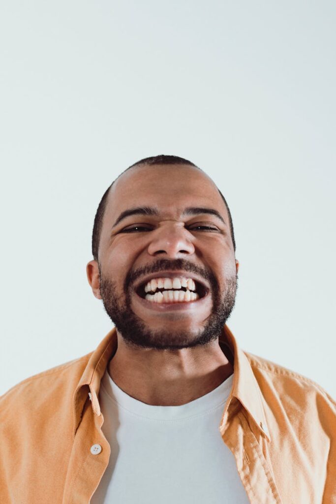 Close-up of an African American man with a big smile, showcasing joy and positivity.