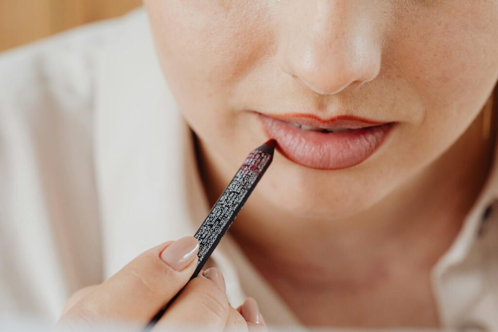 Detailed close-up of a woman applying lip liner for precise makeup application.