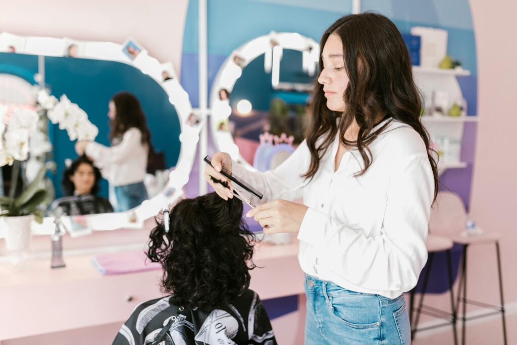 A hairdresser in a modern salon skillfully trims a woman's hair.