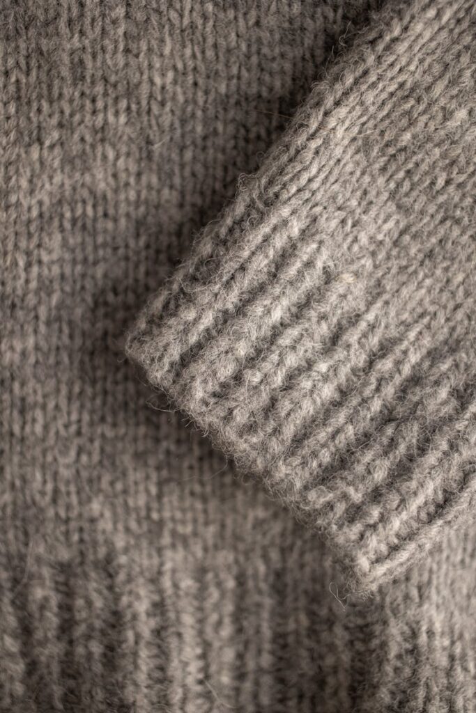 Closeup of a soft wool knitted sweater showcasing texture and design.