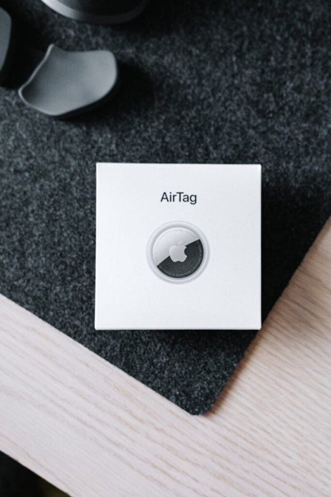 Overhead image of Apple Airtag packaging on a textured surface, showcasing product simplicity.