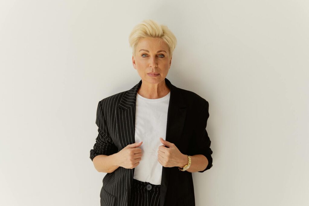 Stylish blonde woman in a pinstripe suit exuding confidence.