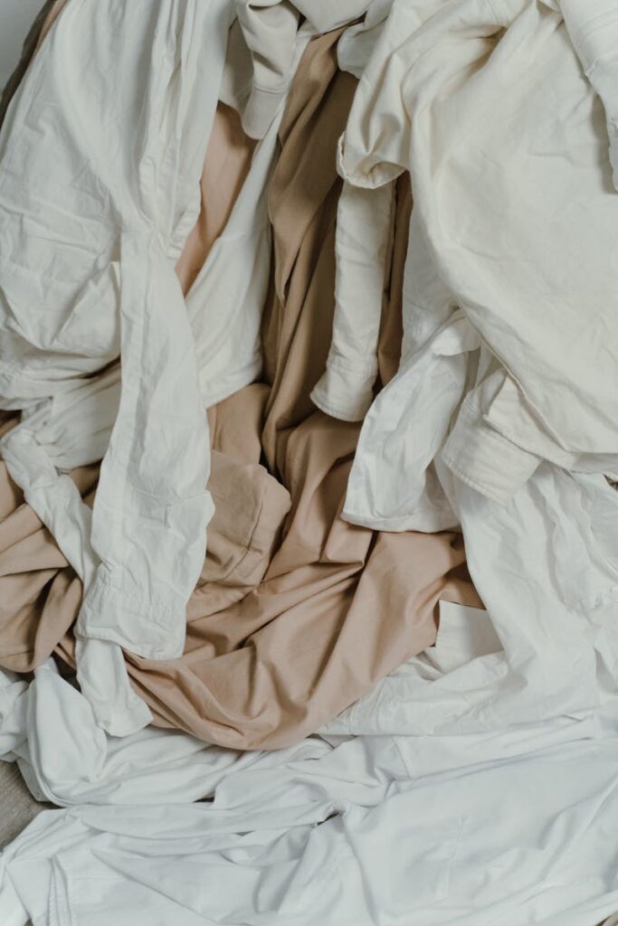 A heap of beige and white fabrics showcasing texture and wrinkles, ideal for textile concepts.