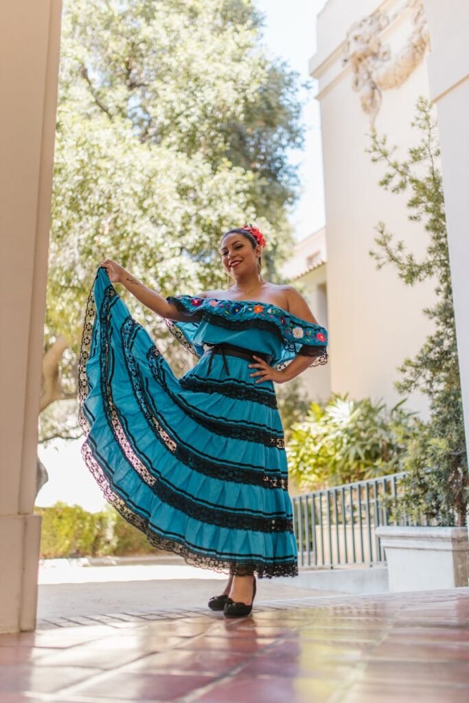 Colorful portrait of a woman in traditional Mexican dress dancing outdoors.