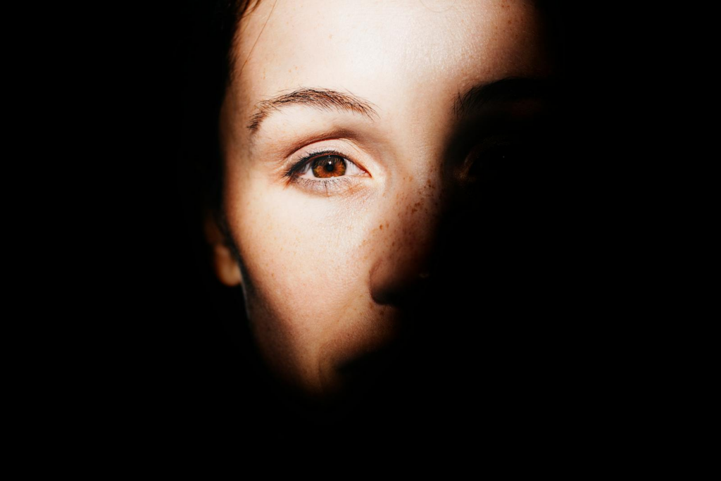 A striking portrait highlighting a woman's eye with dramatic light and shadow play.