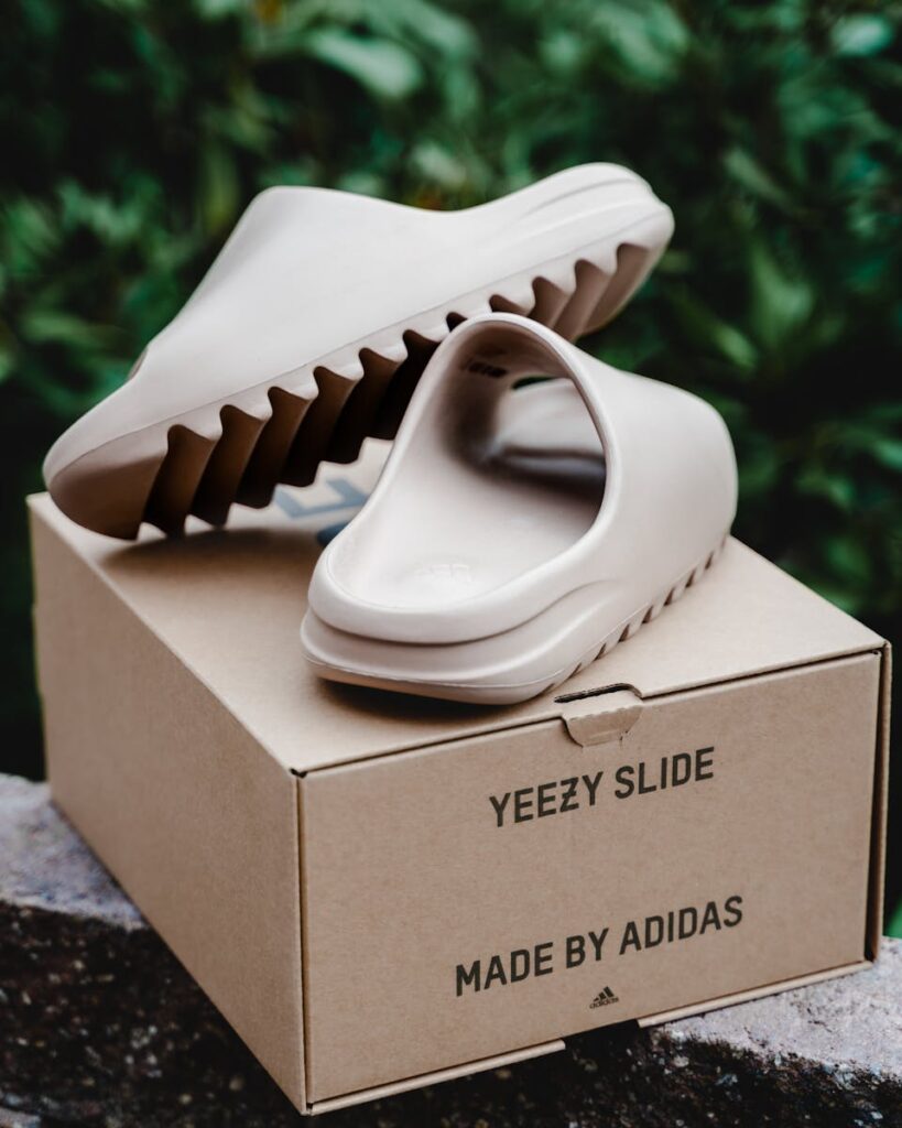 Adidas Yeezy Slide placed on box in an outdoor setting, highlighting product design.